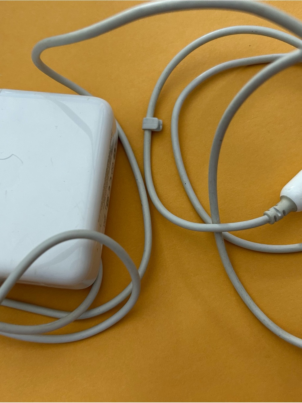 Apple MagSafe power adapter for MacBook laptops.